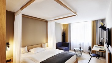 Bequemes Hotelzimmer mit Bett, Sitzbereich und Schreibtisch
