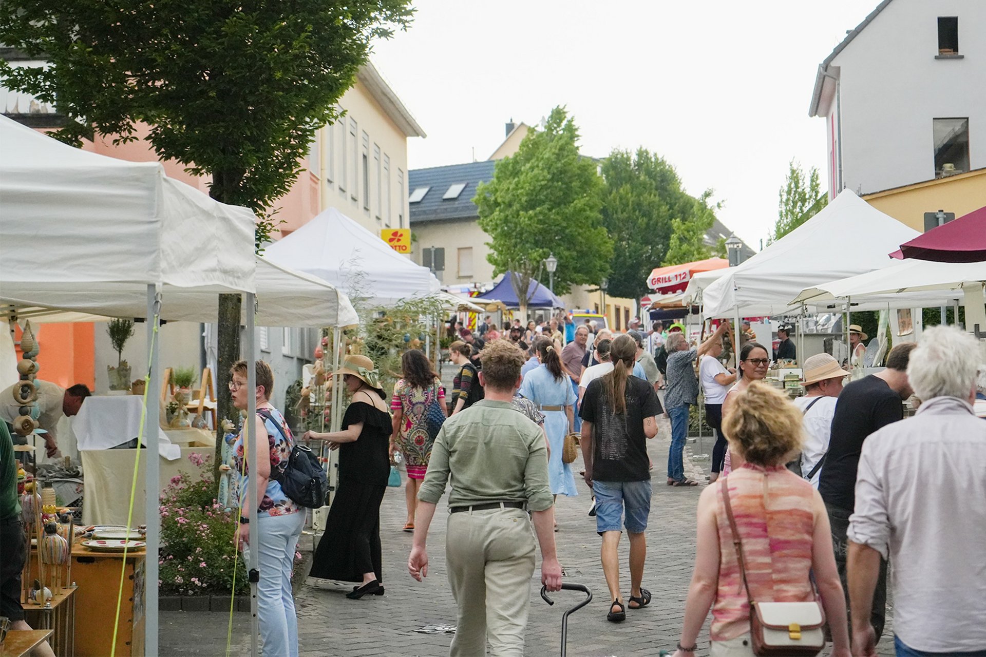 Menschenmenge besucht einen Markt mit verschiedenen Ständen und Ständen