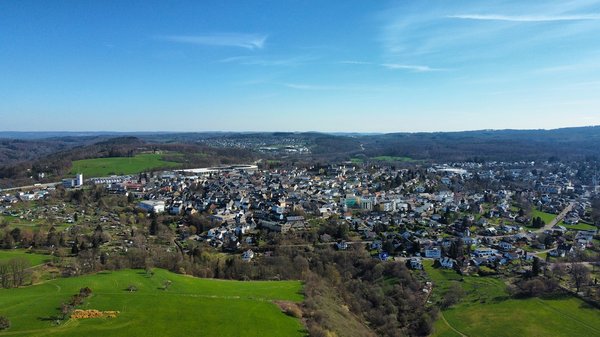 Panoramaansicht einer Stadt umgeben von Grün und Hügeln