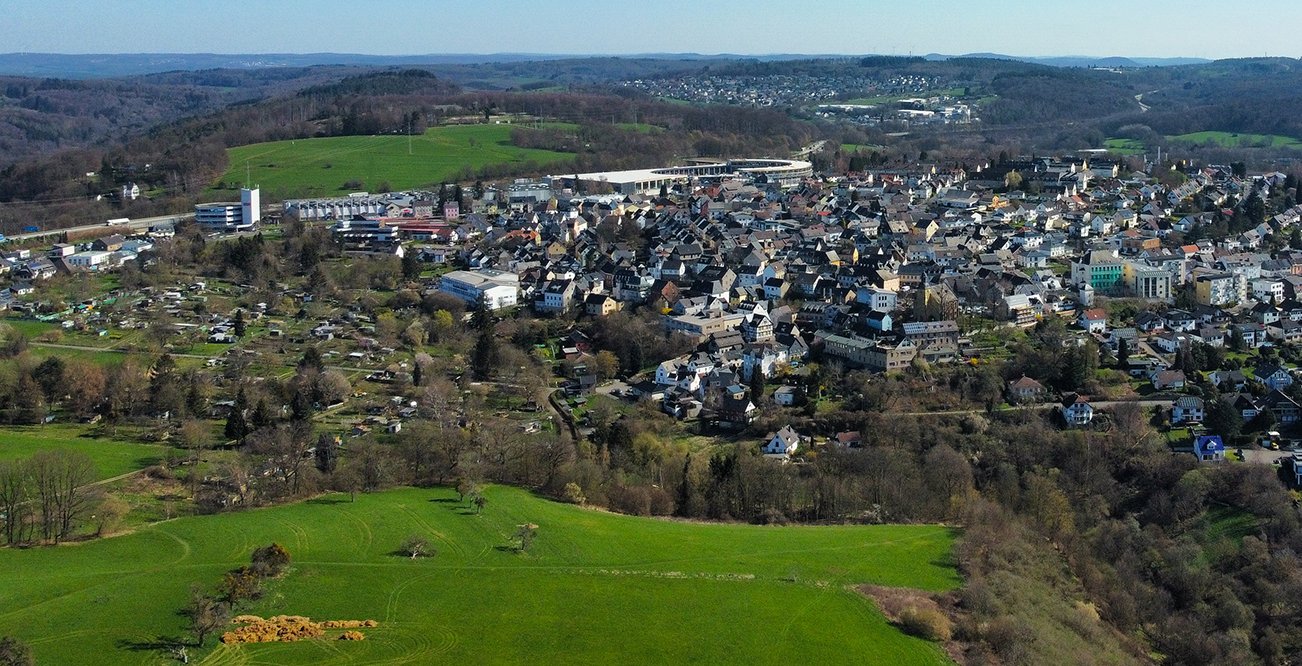 Panoramaansicht einer Stadt umgeben von Grün und Hügeln