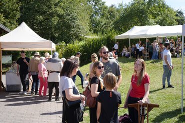 Gruppengespräch und Aktivitäten auf einem Markt im Freien